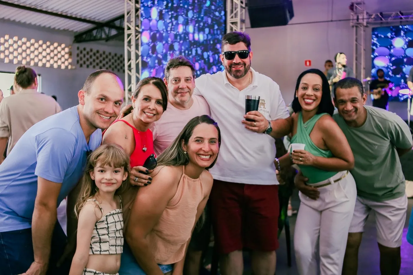 Grupo de amigos e famílias reunidos e sorrindo no almoço do #OBEM