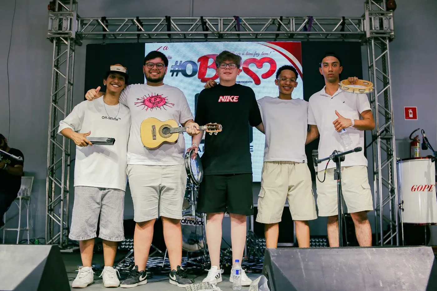Grupo 4 e Meio no palco do #OBEM, com cavaquinho, pandeiro e tamborim