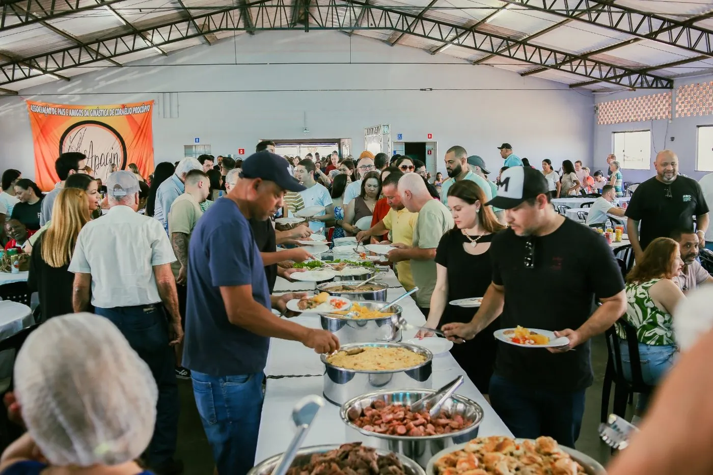 Fila do buffet sendo servida pelos voluntários
